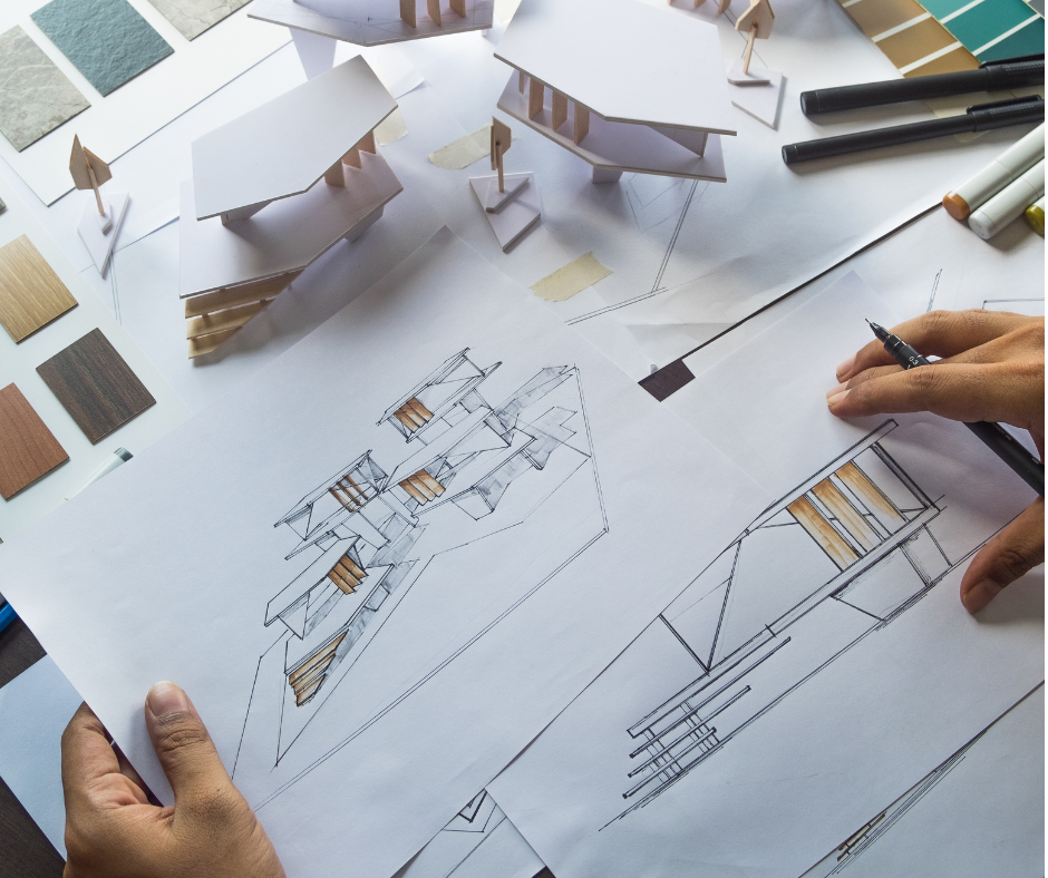 Architekturmodelle, Skizzen und Materialmuster auf einem Arbeitstisch