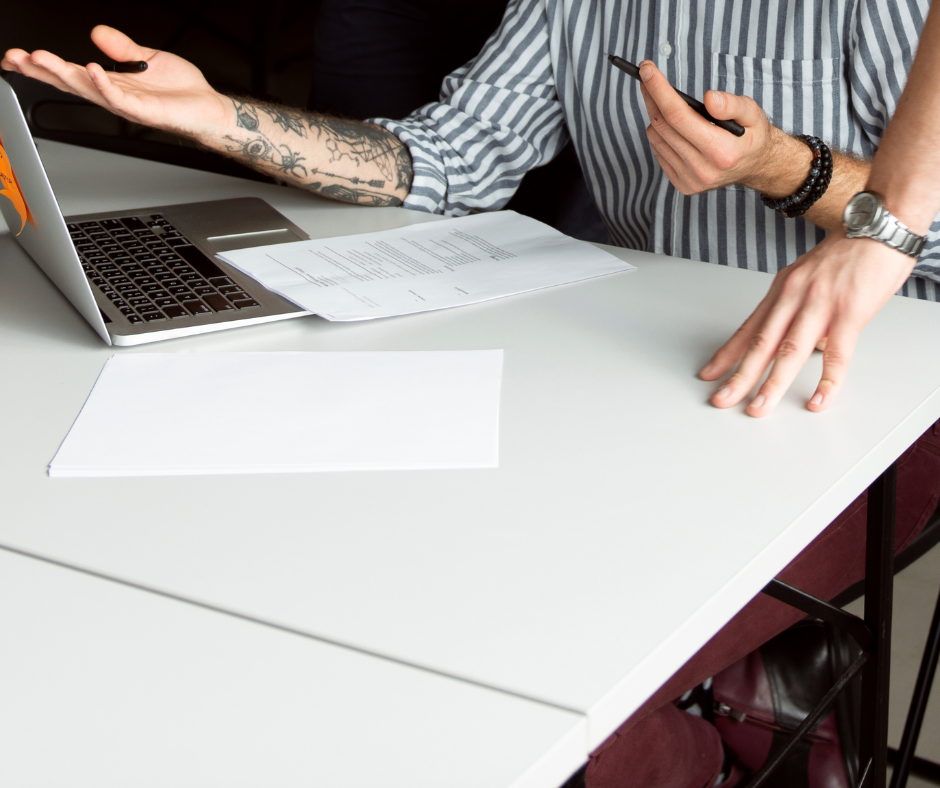 Geschäftsbesprechung mit Laptop und Dokumenten am Tisch